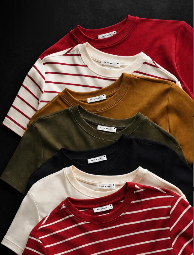 Seven Fave Wear premium cotton t-shirts laid flat on a dark background